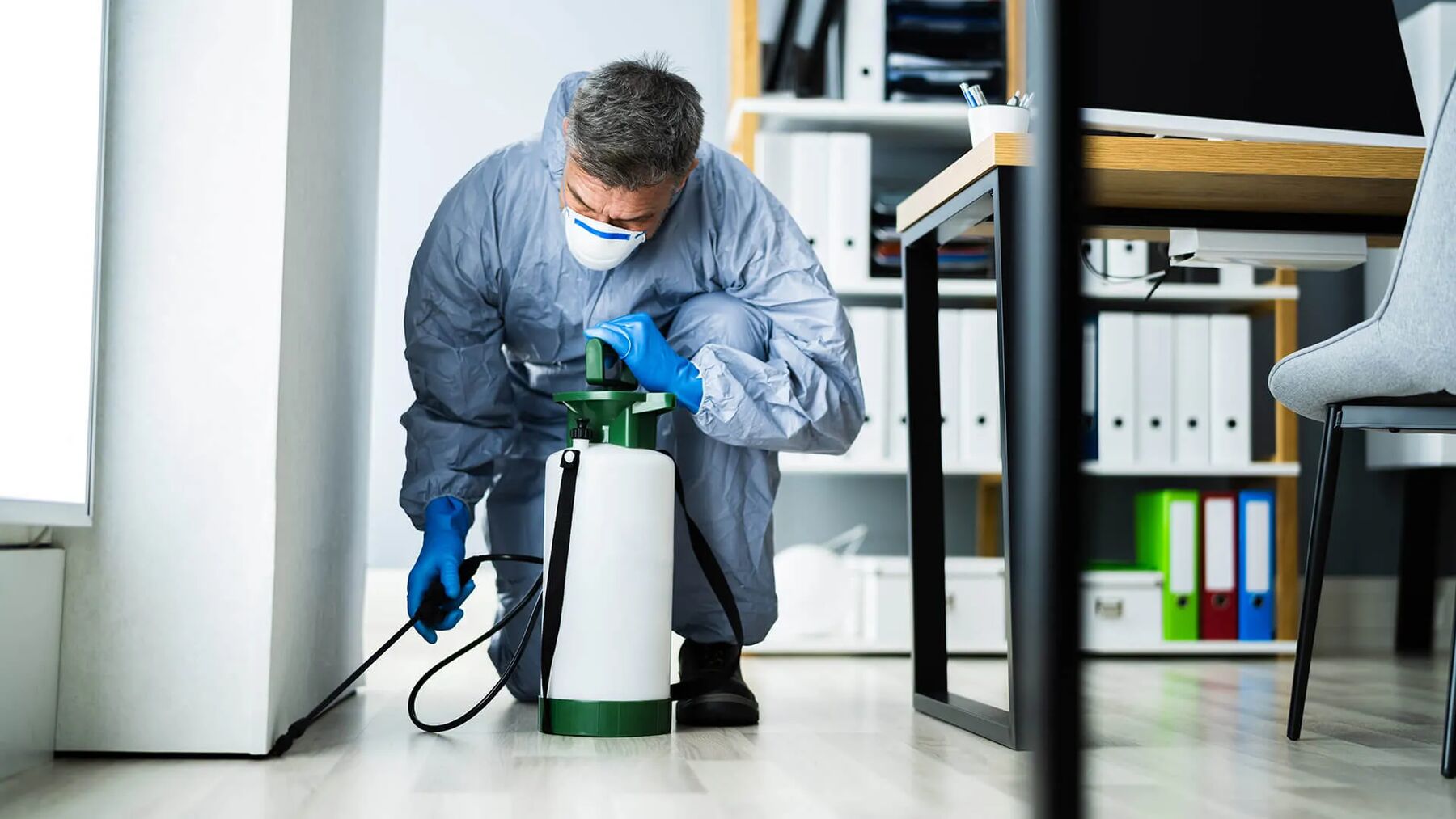 Northeast Exterminators technician treating a home interior